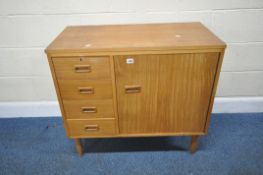 A MID-CENTURY TEAK CASED ELECTRIC SINGER SEWING MACHINE, with a hinged lid, a cupboard door, and