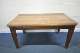 AN EARLY 20TH CENTURY OAK RECTANGULAR DINING TABLE, with canted corners, raised on square tapered