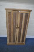 A LIMED OAK DOUBLE DOOR CUPBOARD, with four adjustable shelves, width 81cm x depth 39cm x height