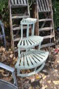 A PAINTED PINE QUARTER CIRCLE GRADUATED PLANT POT STAND with three levels, height 92cm