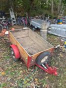 A SMALL TRAILER with wooden slatted sides one axle and towing hitch bed width 76cm length 122cm