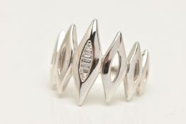 A CONTEMPORARY DIAMOND DRESS RING, designed as seven white gold navette form panels, the central