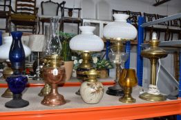 A GROUP OF OIL LAMPS ETC, comprising seven oil lamps in different materials and designs, a brass