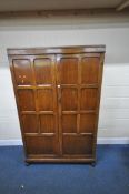A 20TH CENTURY OAK DOUBLE DOOR WARDROBE, with a mirror to the inside of the right hand door, width