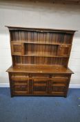 A SOLID OAK DRESSER, the with two shelves, and two doors, atop a base with three drawers over