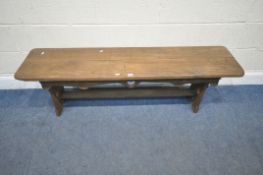 AN EARLY 20TH CENTURY BENCH, raised on trestle legs, with heart details, united by a stretcher,