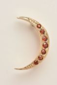 A 9CT GOLD GARNET SET CRESCENT BROOCH, set with a row of graduating circular cut garnets, fitted