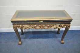 A REPRODUCTION FRENCH GILT AND EBONISED SIDE TABLE, with a composite insert, scrolled and foliate