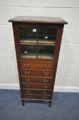 HORNE, THOMPSON & CO, AN EDWARDIAN MAHOGANY MUSIC CABINET, with a glazed door, over six fall front