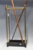 A BRASS STICK STAND WITH TWO WALKING STICKS, the stick stand with cast iron base, drip tray and