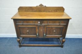 AN EARLY 20TH CENTURY OAK SIDEBOARD, with a raised back, two drawers over double cupboard doors,