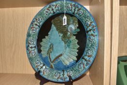 AN ITALIAN MAIOLICA CHARGER, moulded in relief depicting a woman in profile, appears to be in late