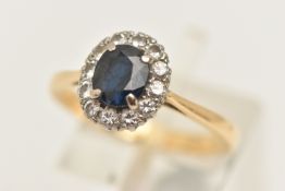 AN 18CT GOLD SAPPHIRE AND DIAMOND CLUSTER RING, of an oval form, set with a central oval cut deep
