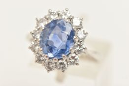 A DIAMOND AND CERTIFIED SAPPHIRE CLUSTER RING, an oval cut blue sapphire, set with a surround of