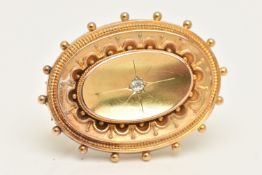 A 15CT GOLD BROOCH, an oval form Etruscan style brooch, centrally set with a single old cut diamond,