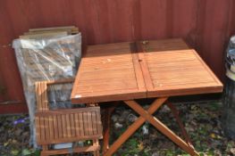 A FOLDING HARDWOOD GARDEN TABLE AND SIX CHAIRS with steel frames and slatted wooden seat and back