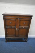 AN EARLY 20TH CENTURY OAK DOUBLE DOOR CABINET, with an arrangement of shelves, raised on barley
