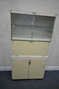 AN EASTHAM MID-CENTURY KITCHEN CABINET, the double glass sliding doors enclosing an arrangement of