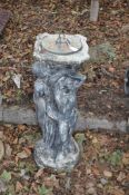 A CONCRETE SUNDIAL, in the form of three ladies around a column with a brass dial, height 83cm.