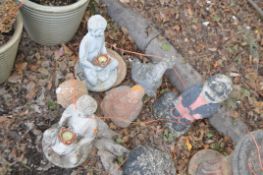 SIX CONCRETE AND PLASTIC GARDEN FIGURES, including a pair of oriental figure seated holding lotus