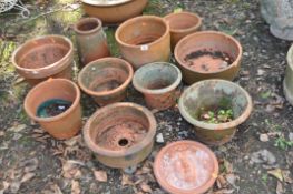 A COLLECTION OF SMALL TERRACOTTA PLANT POTS AND A PLAQUE, the largest pot 34cm in diameter.