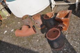 A COLLECTION OF TERRACOTTA ITEMS, including four strawberry pot bowls (no lid or platter), a chimney