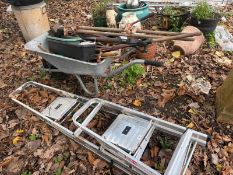 A WHEELBARROW GARDEN TOOLS AND A STEP LADDER including hoes, forks, spades, etc