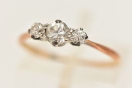 A YELLOW METAL THREE STONE DIAMOND RING, two round brilliant cut diamonds and one transitional cut