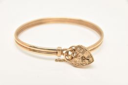 A 9CT GOLD BANGLE WITH HEART PADLOCK CLASP, double bangle, fitted with a foliate pattern heart