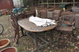 A HARDWOOD 'FIRMAN' GARDEN TABLE with six folding hardwood chairs with cushions (inside saleroom)