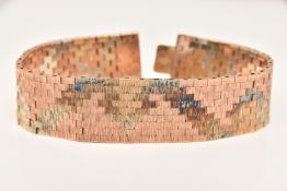 A 9CT GOLD TRI-COLOUR ARTICULATED BRACELET, with a textured pattern, fitted with a push piece