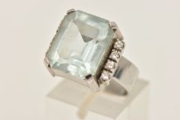 A WHITE METAL GEM SET RING, set with a large light blue emerald cut stone assessed as paste, four