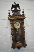 AN EARLY 20TH CENTURY VIENNA WALL CLOCK, with an Eagle pediment, flanked by twin finials, over an