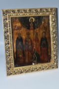 AN ORTHODOX ICON depicting two male and two female figures stood below an image of the Virgin Mary