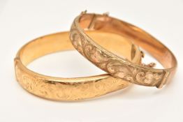 TWO 9CT GOLD METAL CORE HINGE BANGLES, the first decorated with a foliate pattern, fitted with a
