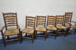 A SET OF SIX OAK LADDERBACK CHAIRS, with rush seats, including two carvers, condition report: scuffs