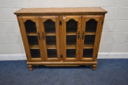 AN OAK BOOKCASE, fitted with two sets of double cupboard doors, width 127cm x depth 35cm x height