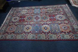 A RED GROUND RECTANGULAR WOOLLEN RUG, with repeating geometric patterns, surrounded by a multi-strap