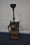 A BLACK PAINTED CAST IRON THREE TIER WHAT-NOT, with a central oil lamp cradle, each corner with head