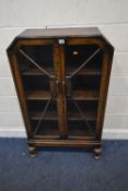 AN EARLY 20TH CENTURY OAK BOOKCASE, with double glass doors, raised on turned front legs, width 78cm