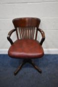 A 20TH CENTURY MAHOGANY SWIVEL OFFICE CHAIR, with open armrests, leather upholstered seat, raised on