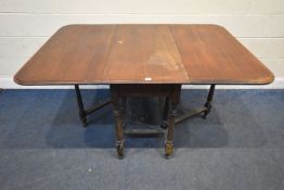 AN EARLY 20TH CENTURY MAHOGANY GATE LEG TABLE, raised on block and turned legs, united by