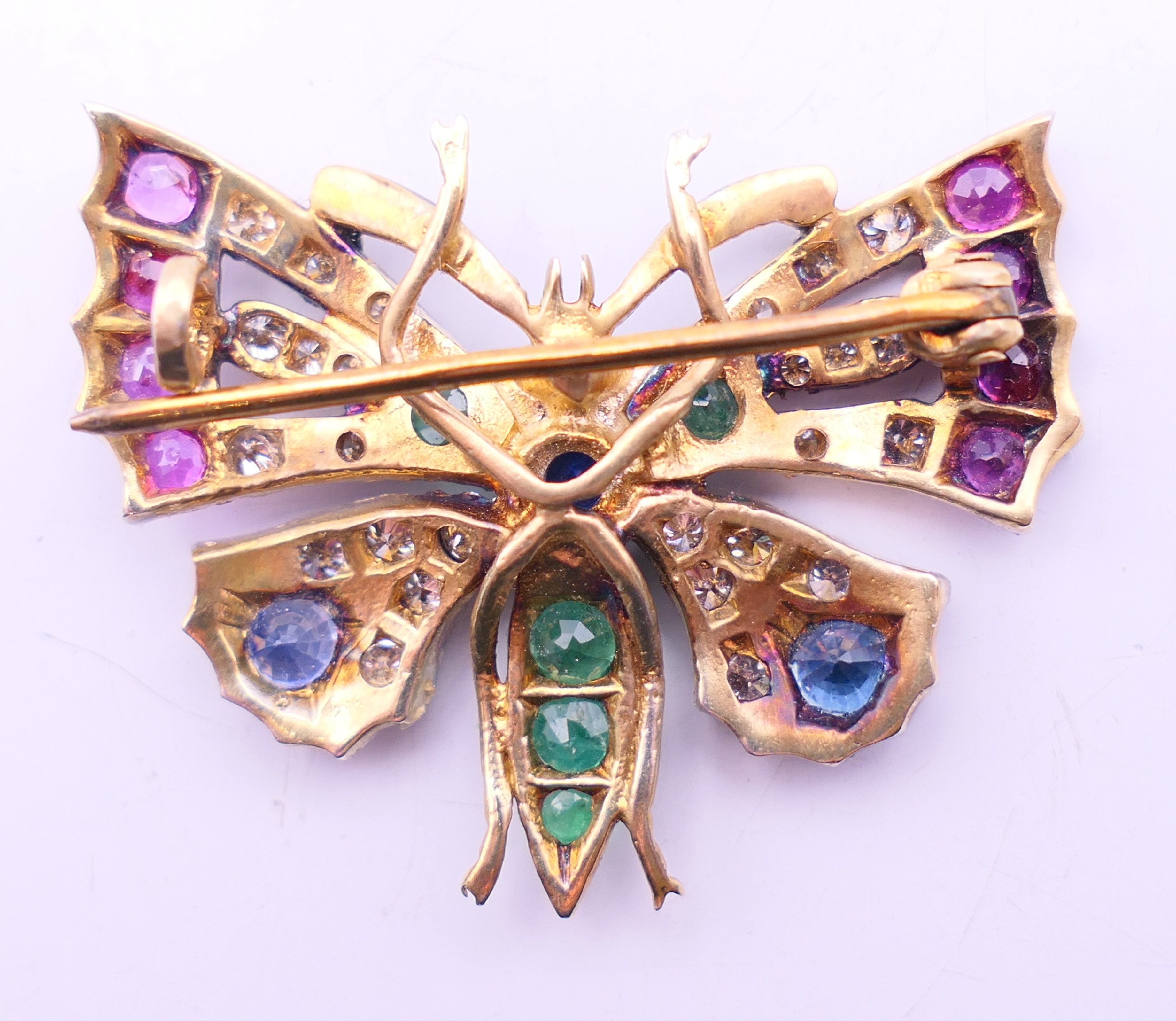 An unmarked gold multi gem set butterfly brooch. 3.5 cm x 2.75 cm. - Image 3 of 3