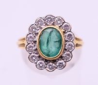 An 18 ct gold, emerald and diamond cluster ring. Ring size N.