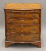 A 20th century walnut bow-front chest of drawers. 70.5 cm wide.