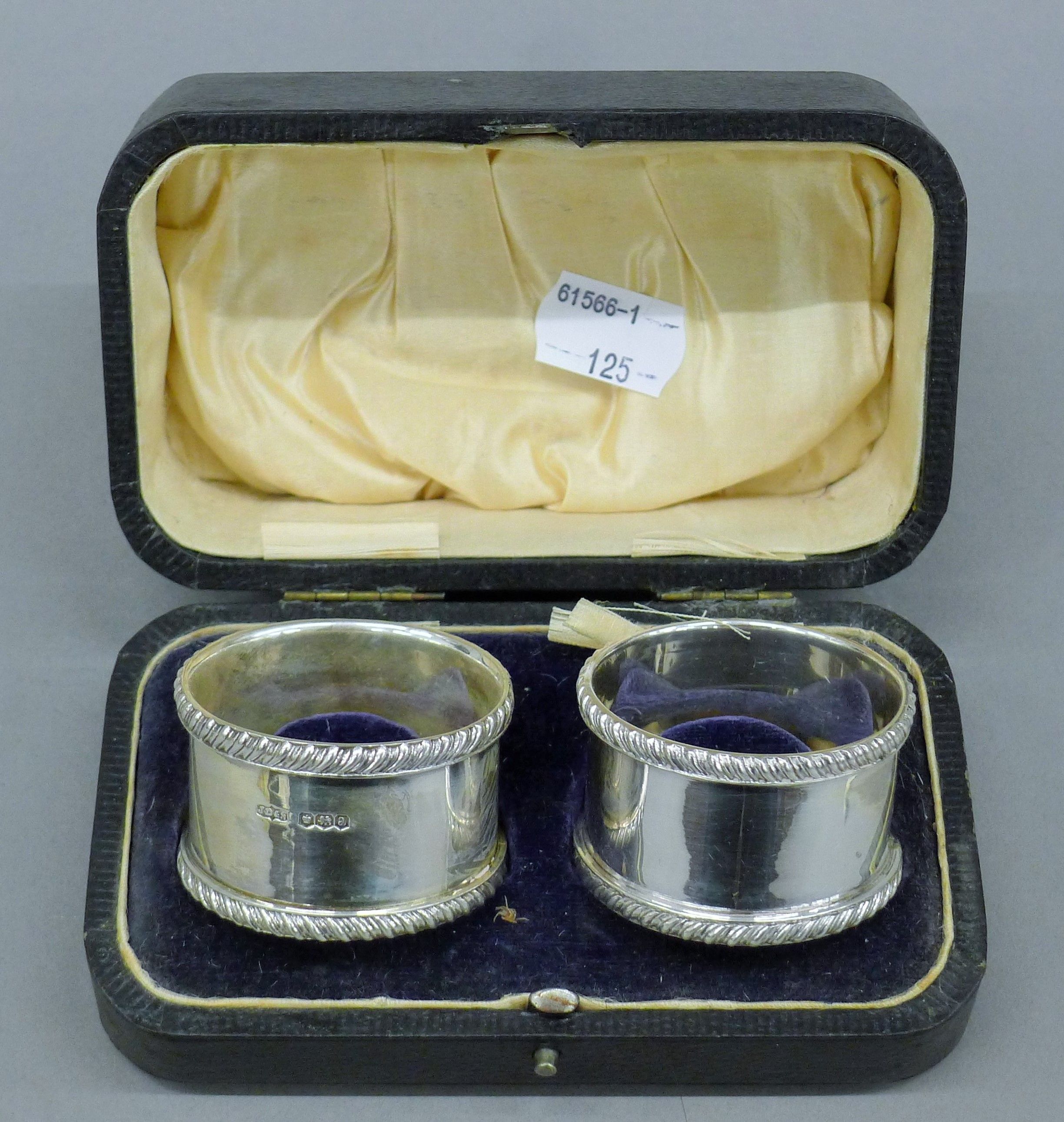 A cased pair of silver napkin rings. The case 13.5 cm wide. 114.5 grammes.