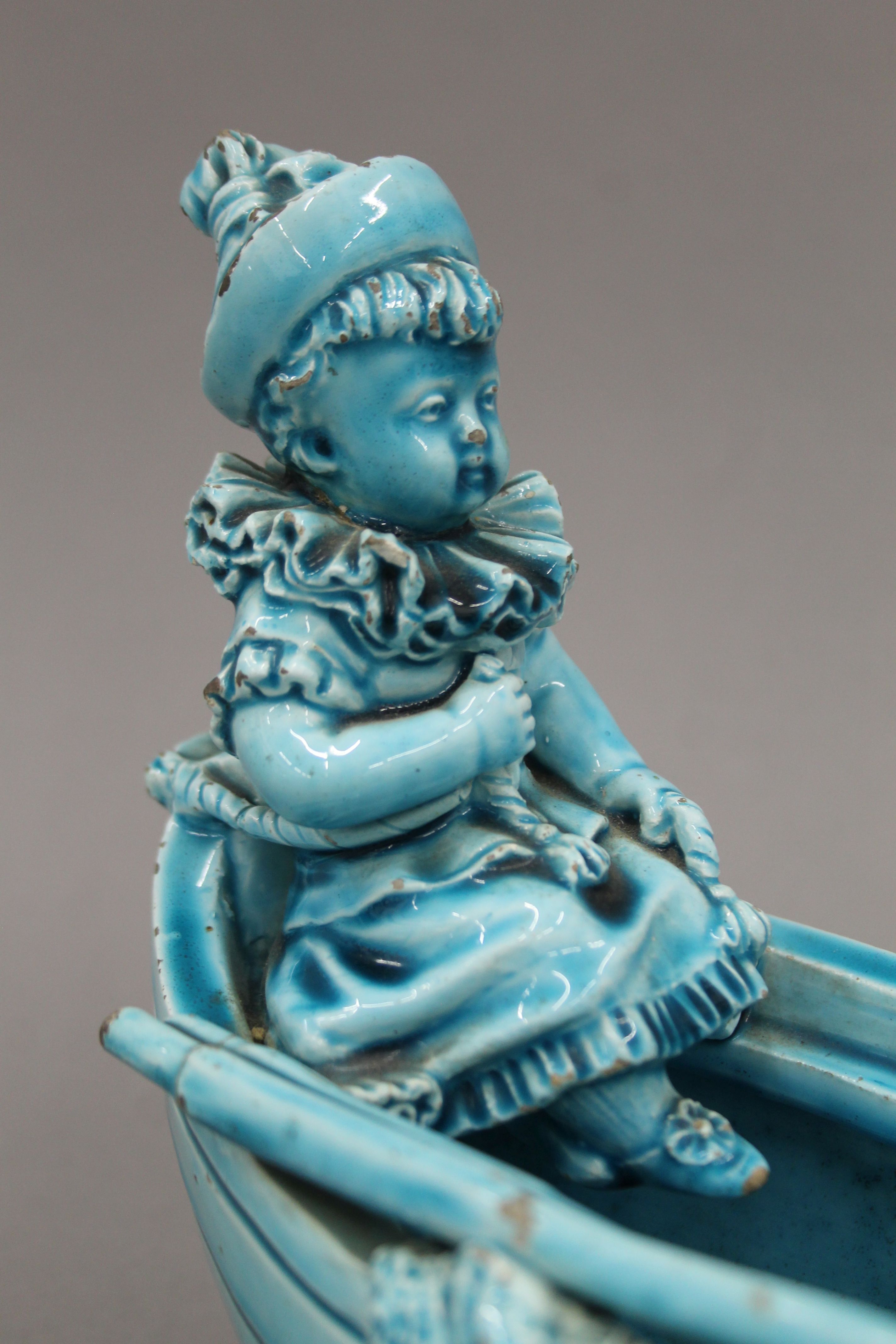 A 19th century blue ground pottery centrepiece formed as clowns in a boat. 31 cm long. - Image 4 of 8