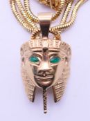 A 9 ct gold Tutankhamun mask pendant 10 grammes total weight, on an 18 ct gold chain 17.8 grammes.