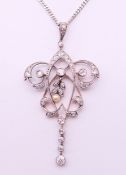An unmarked, diamond and seed pearl pendant on a 9 ct white gold chain.