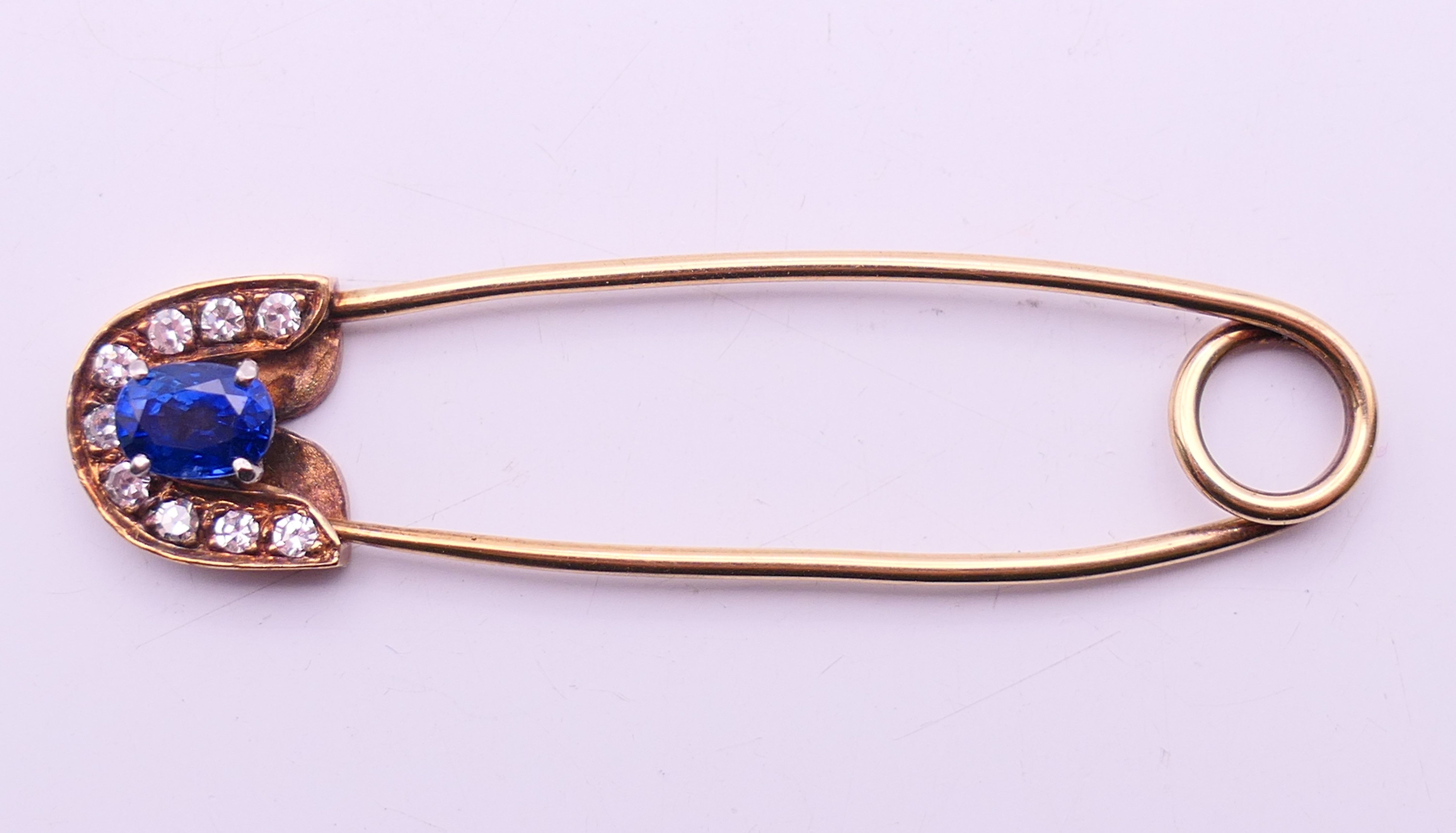 A 9 ct gold stone set safety pin form brooch. 6 cm high. 4.8 grammes total weight. - Image 3 of 6